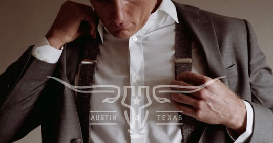 Man adjusting grey wool button-on suspenders with suit jacket — featured image for Stratton Suspender Co.’s complete guide on how to wear suspenders for weddings and menswear.