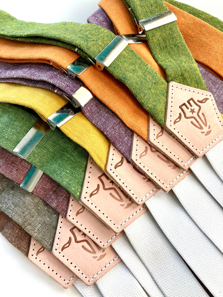 Handmade women’s suspenders with linen straps in assorted colors and patented single magnetic clasp, finished with full-grain leather tabs. Made in Texas, USA.