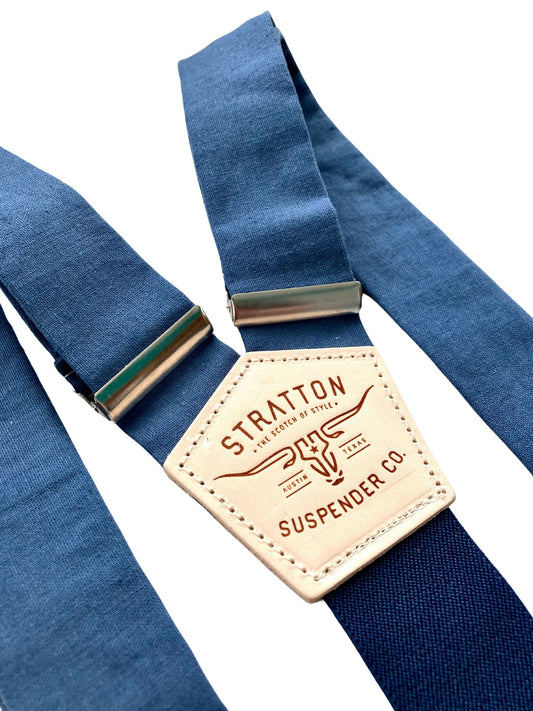 Close-up of French blue linen button-on suspenders with navy back strap, silver hardware, and natural leather patch by Stratton Suspender Co., handmade in the USA for weddings, groomsmen, and vintage menswear.