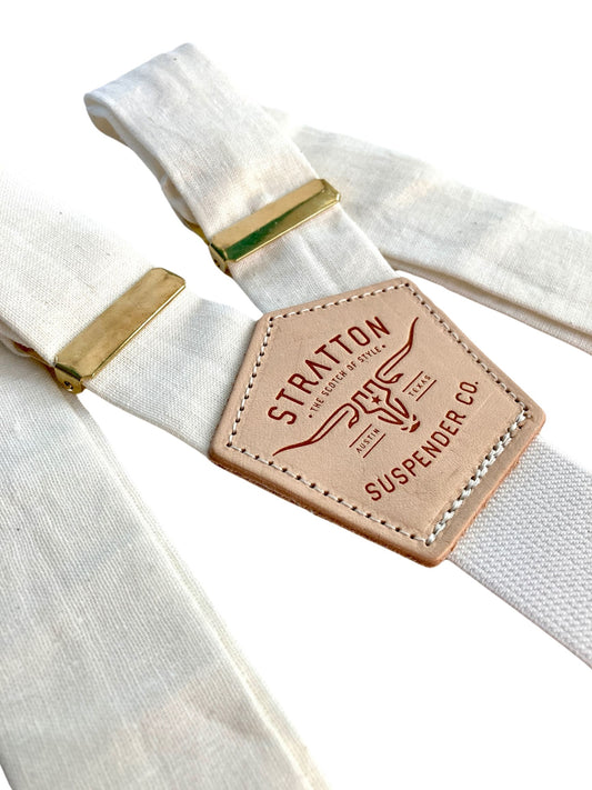 Handmade ivory linen button-on suspenders with full-grain veg-tan leather, gold-colored solid brass hardware, and premium soft twill elastic. Ethically made in Texas, perfect for formal wear, weddings, groomsmen, and heritage menswear. Timeless and refined.