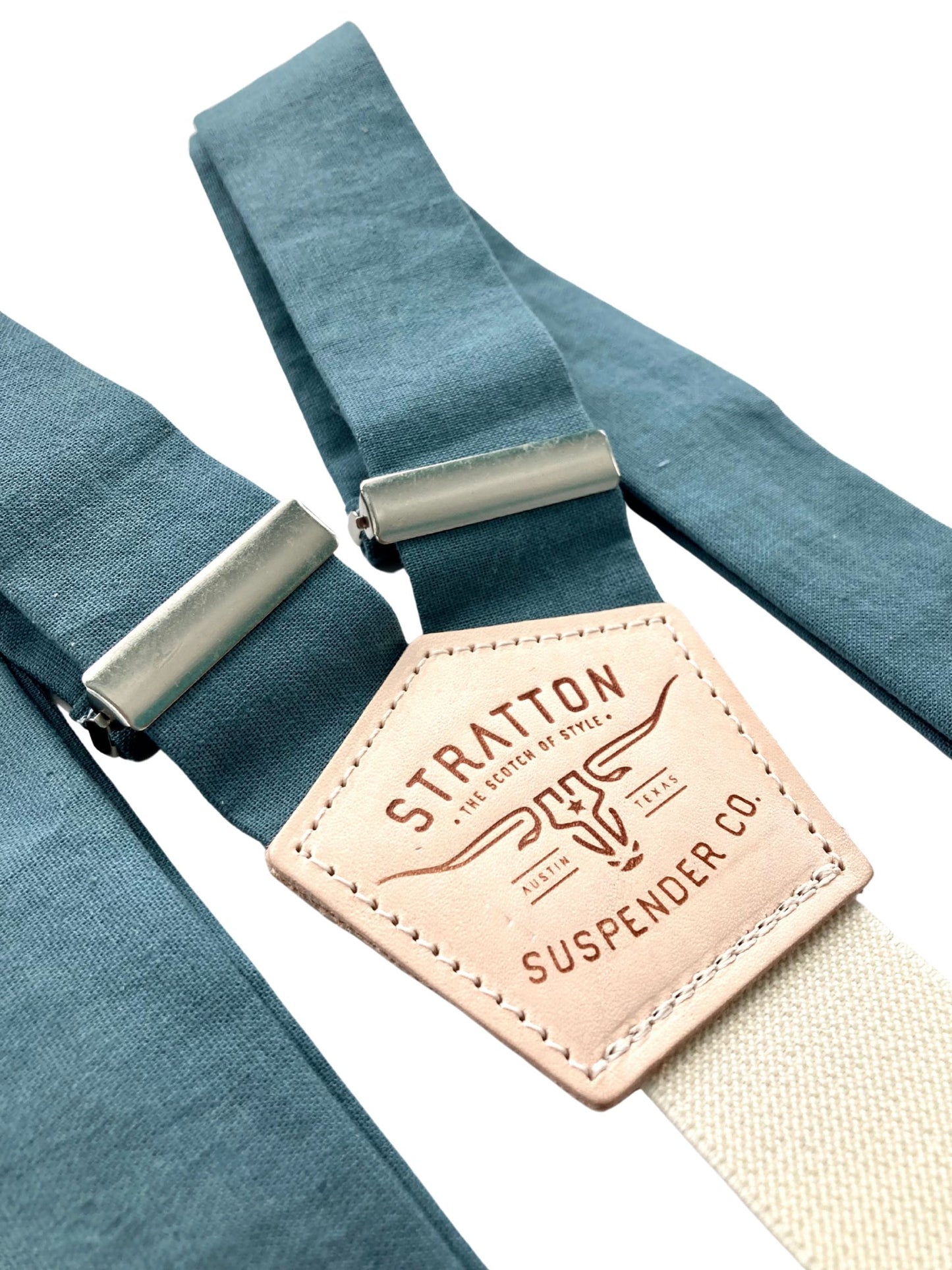 Close-up of handcrafted teal blue linen suspenders with a cream back strap and premium leather detailing. Ideal for wedding suspenders, groomsmen attire, and formal menswear.