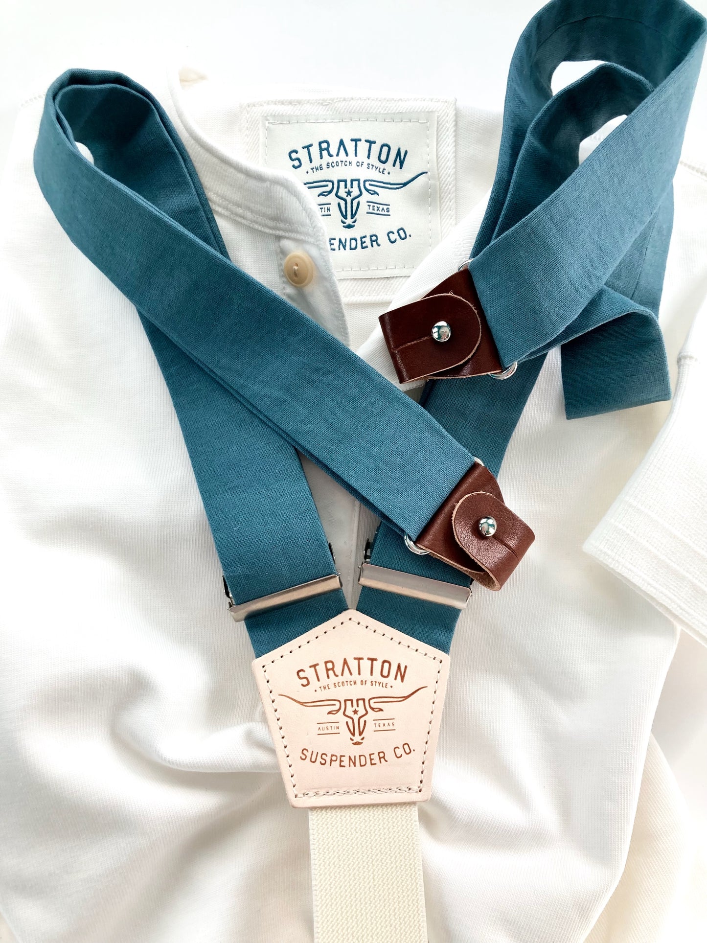 Handmade teal linen button-on suspenders with a cream back strap and chocolate leather button attachments. A premium wedding accessory for groomsmen, rustic weddings, and classic menswear.