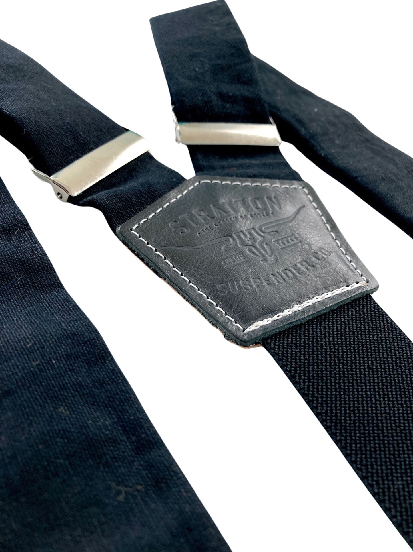Detail close-up of handmade black linen suspenders featuring matching black leather back patch and silver hardware—crafted in Texas for groomsmen, formal events, and classic menswear.