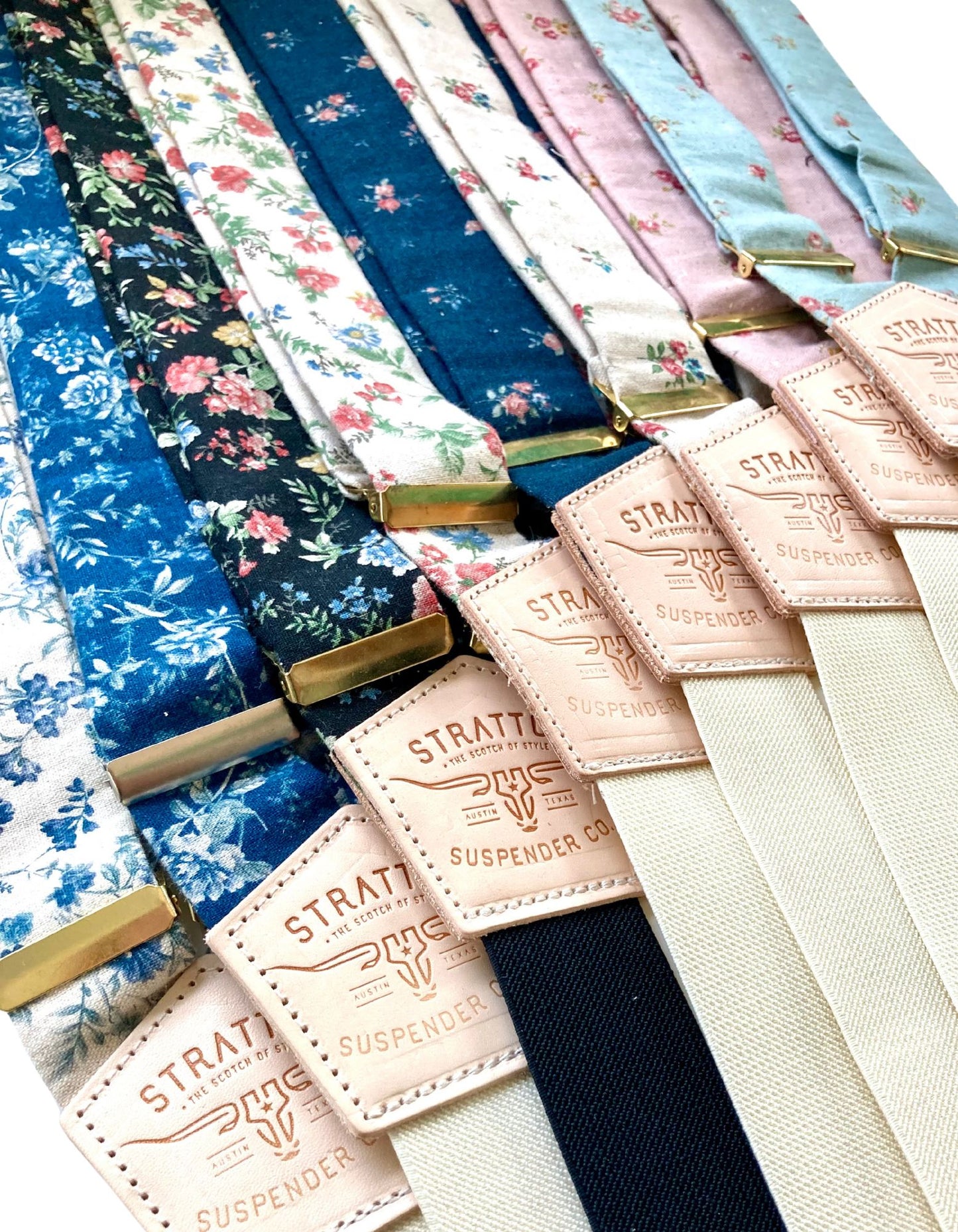 A lineup of bold floral linen suspenders by Stratton Suspender Co., showcasing a variety of prints in navy, black, ivory, and pastels—ideal for weddings, formal events, or standout groomsmen looks.