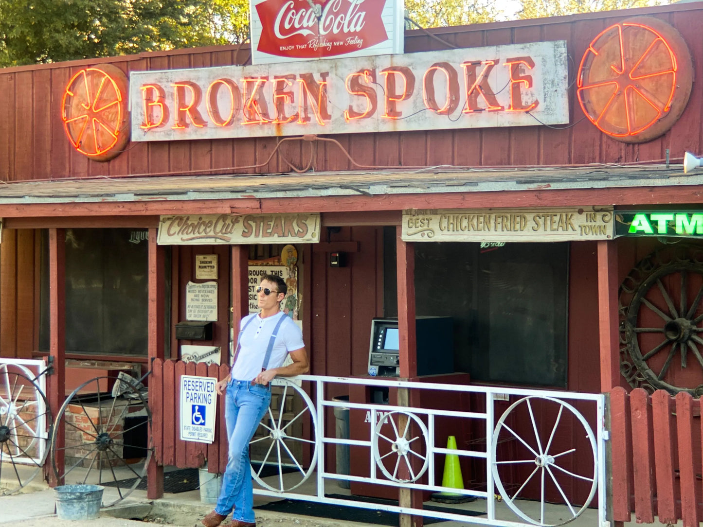Man wearing Stratton Suspender Co. denim blue linen suspenders with button-on leather ends, standing outside the iconic Broken Spoke dancehall on South Lamar in Austin, Texas.