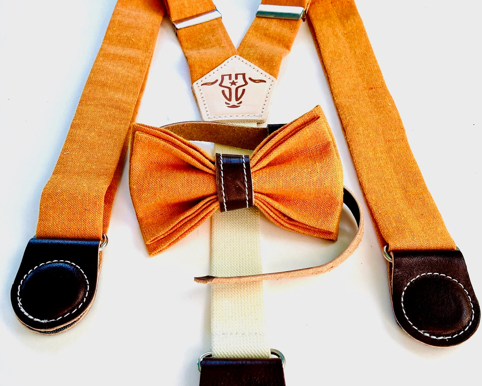 Kids' formal orange linen suspenders with magnetic clasps, brown leather trim, and an optional matching bow tie—ideal for weddings and special occasions.