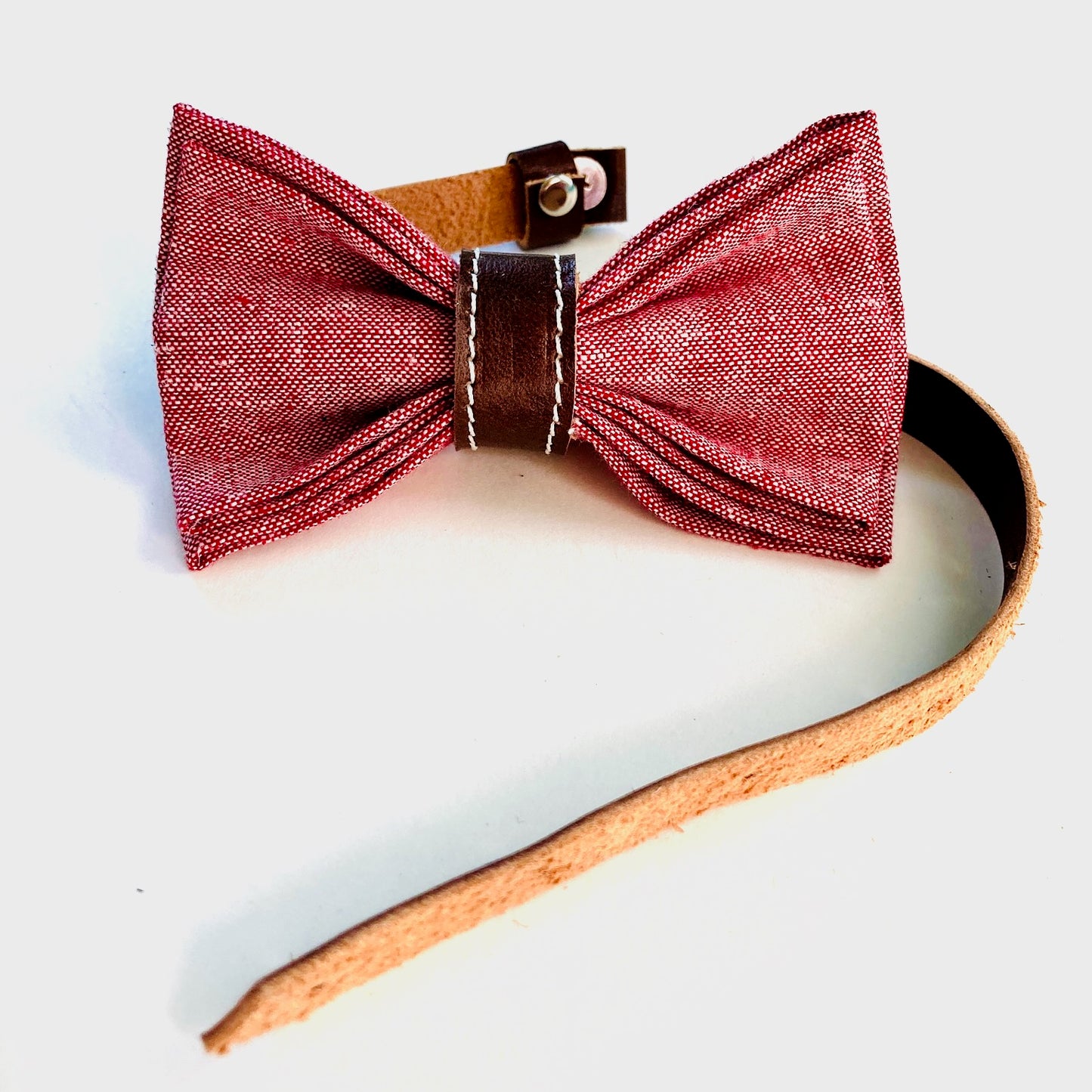 Handmade children’s red linen bow tie with rich chocolate leather accents—adjustable, pre-tied, and perfect for formal events or holidays.