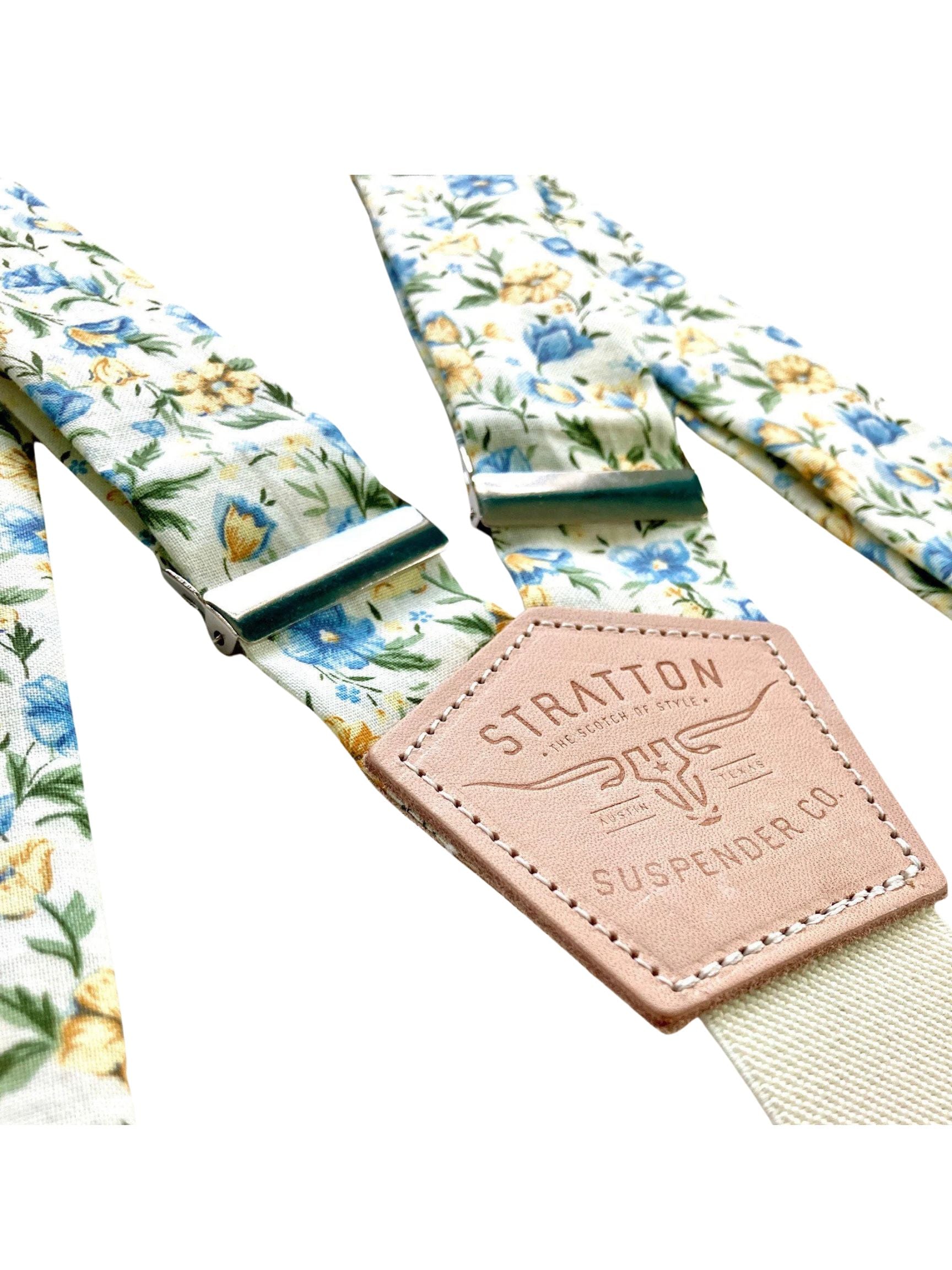 Close-up of cornflower blue and marigold floral button-on suspenders with Stratton Suspender Co. leather patch, handmade wedding accessories.