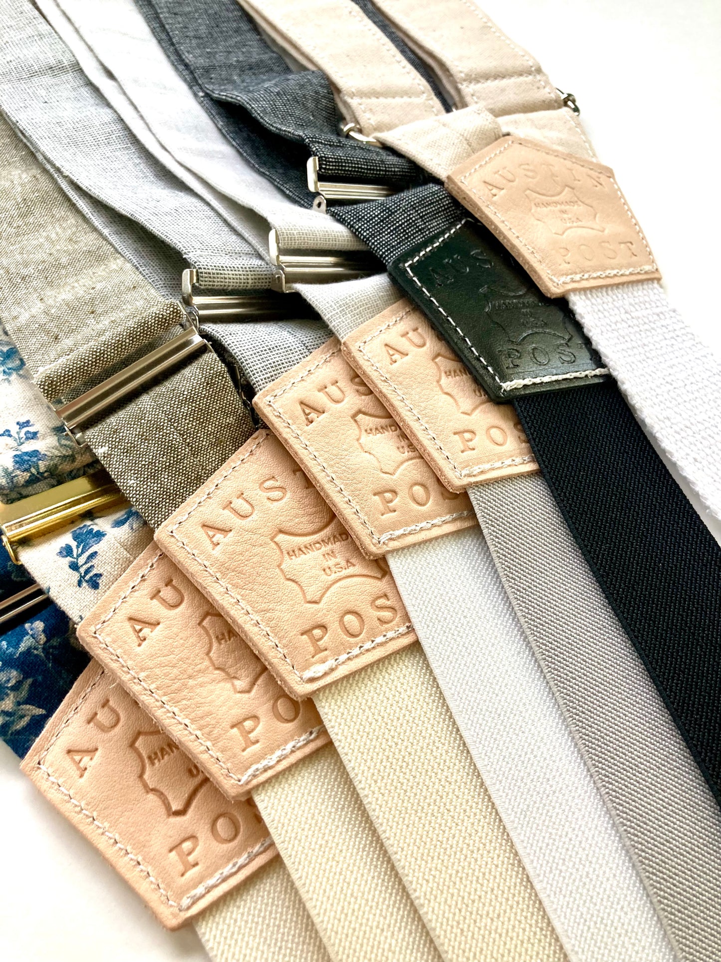 Close-up of handmade canvas and linen suspenders featuring personalized leather back patches with “Austin Post” embossing, showcasing custom groomsmen suspenders ideal for rustic weddings, gifts, and formalwear.
