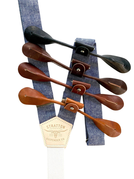Denim blue linen suspenders with full-grain leather button-on ends in four rich tones — black, dark brown, chocolate, and chestnut — shown with Stratton Suspender Co. embossed back patch. Formal, handmade groomsmen braces for weddings or vintage menswear looks.