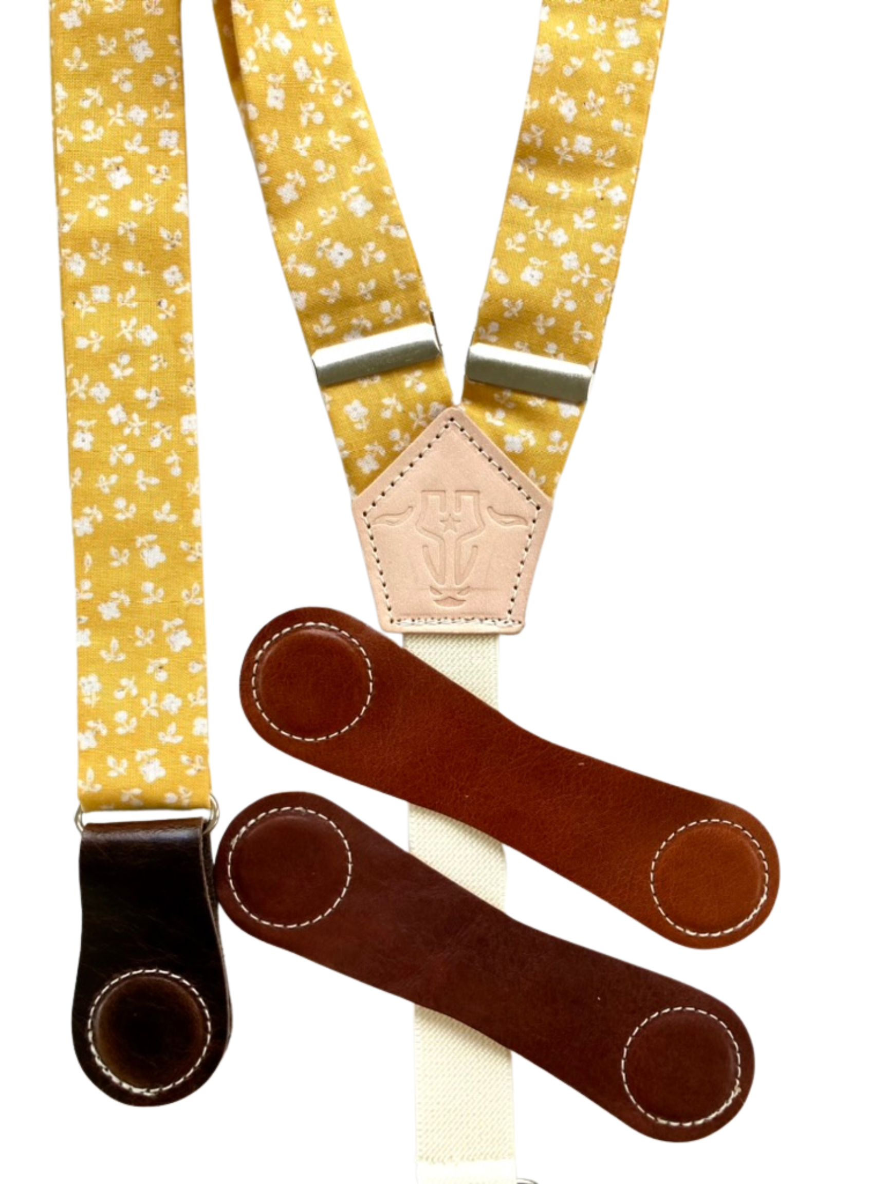 Close-up of marigold yellow floral suspenders with interchangeable leather magnetic clasps, handmade in Texas.