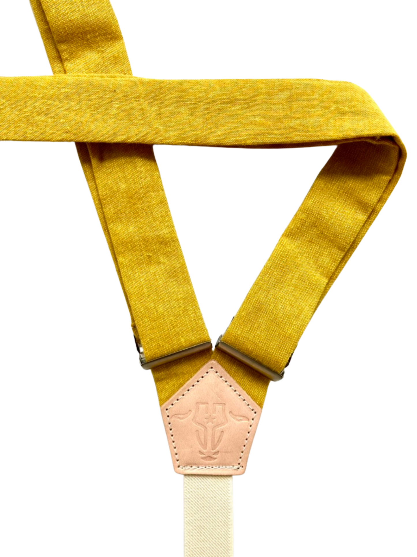 Back detail of mustard yellow women’s linen suspenders with a leather back patch, handcrafted in Texas.