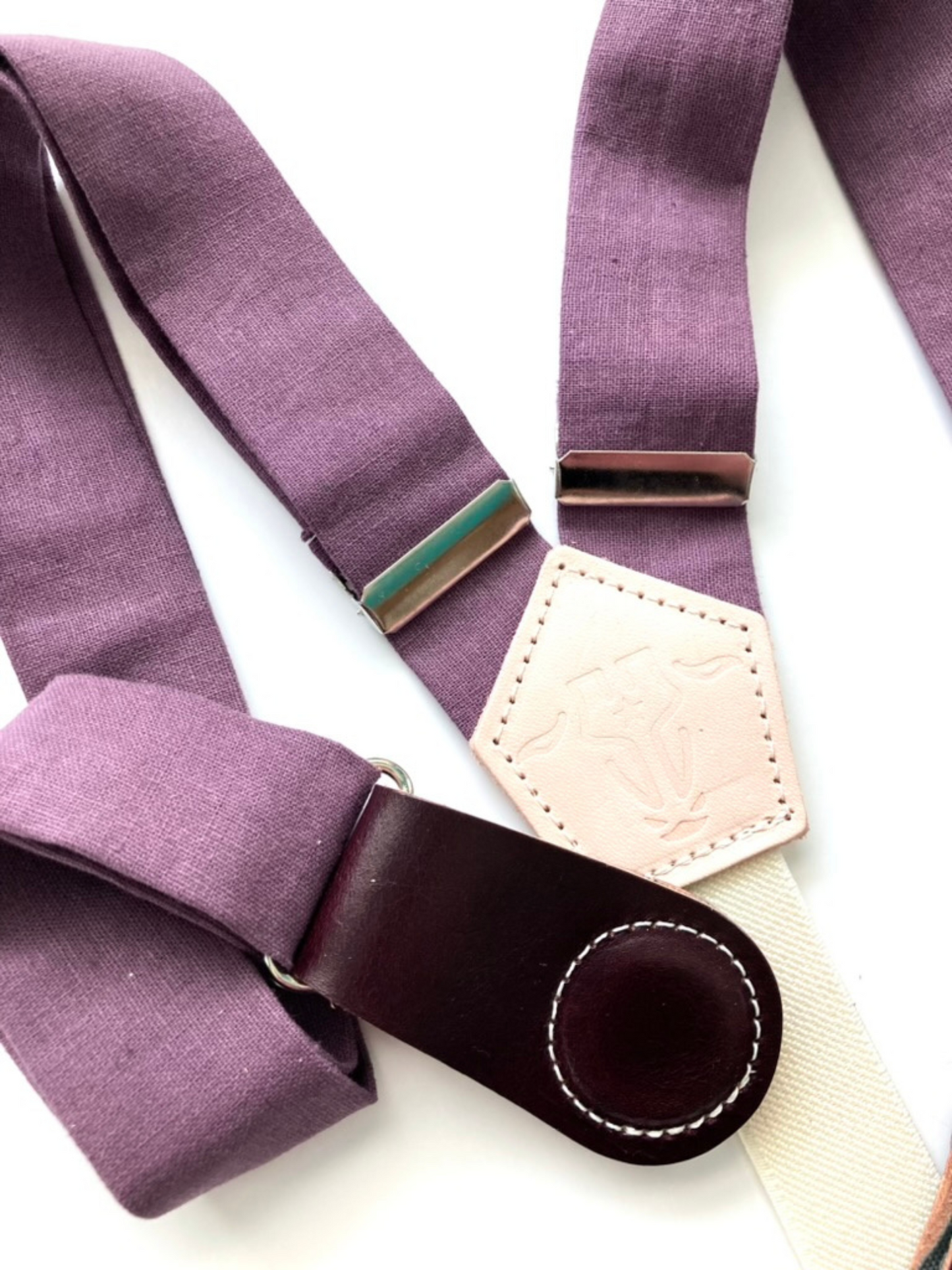 Plum linen women’s suspenders with wine leather magnetic clasps, close-up view of premium stitching and fabric.