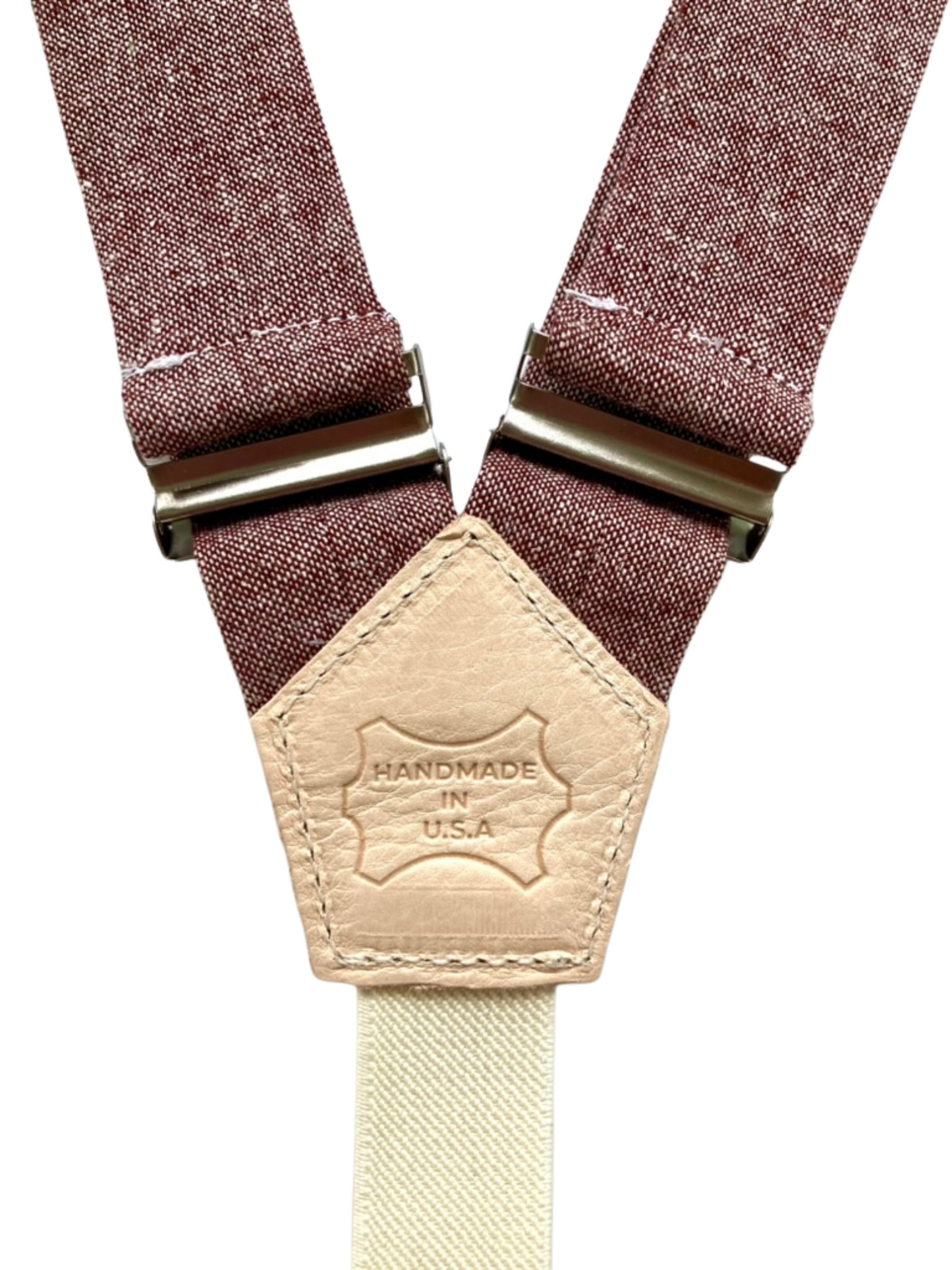 Close-up of Handmade in U.S.A. leather patch on rust maroon women’s linen suspenders, handcrafted in Texas.