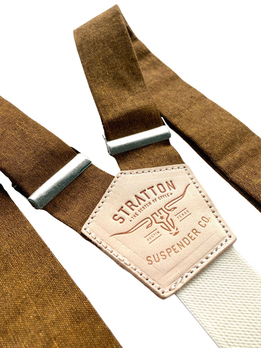 Close-up of handmade copper brown linen suspenders with cream elastic back strap, silver adjusters, and embossed leather patch. Made in Texas by Stratton Suspender Co., ideal for grooms, groomsmen, and rustic wedding style.