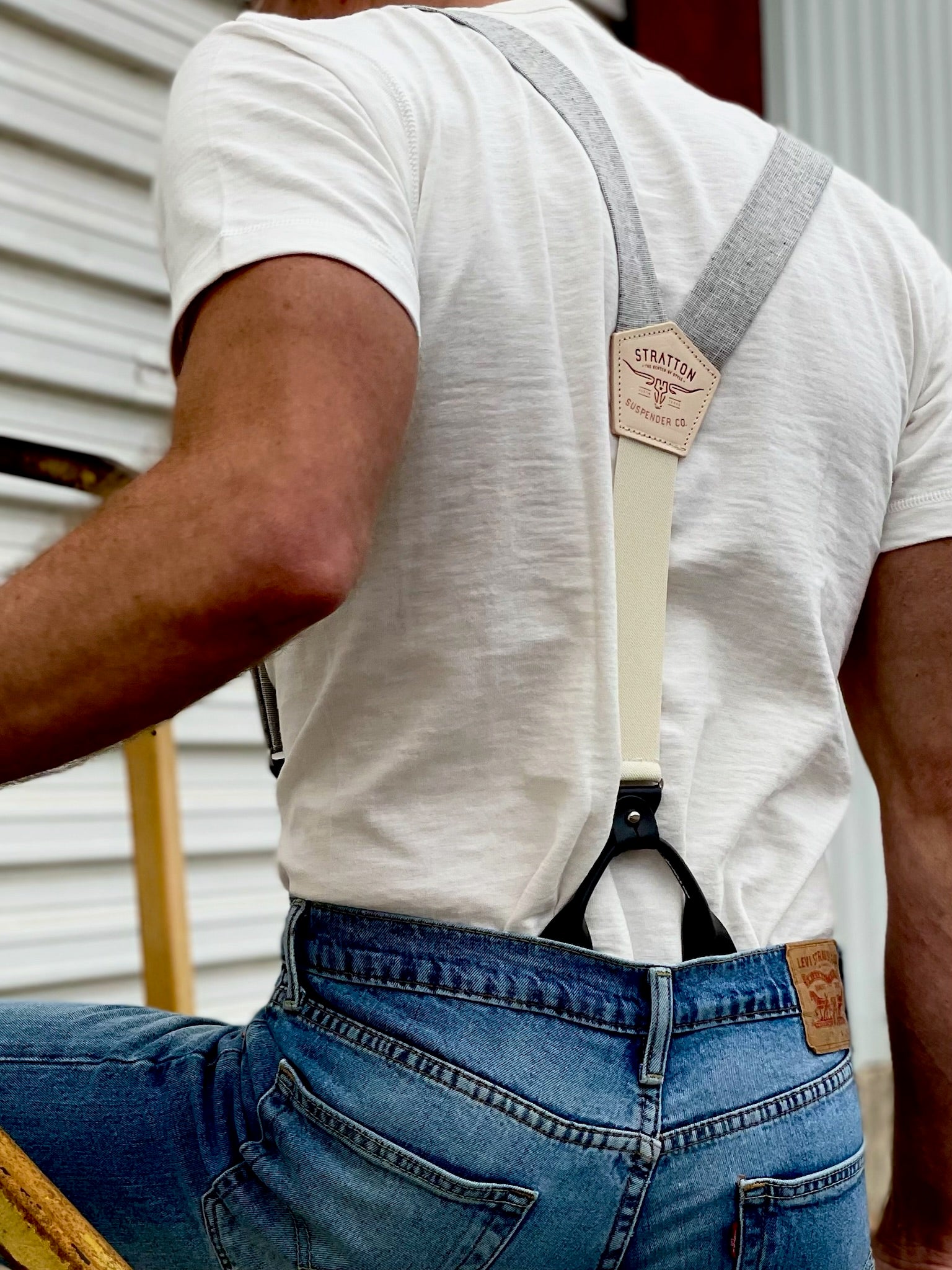 Gray linen suspenders with cream elastic back and leather button-on tabs, shown worn with jeans and a white tee. Handmade in Texas by Stratton Suspender Co. for modern rustic style.