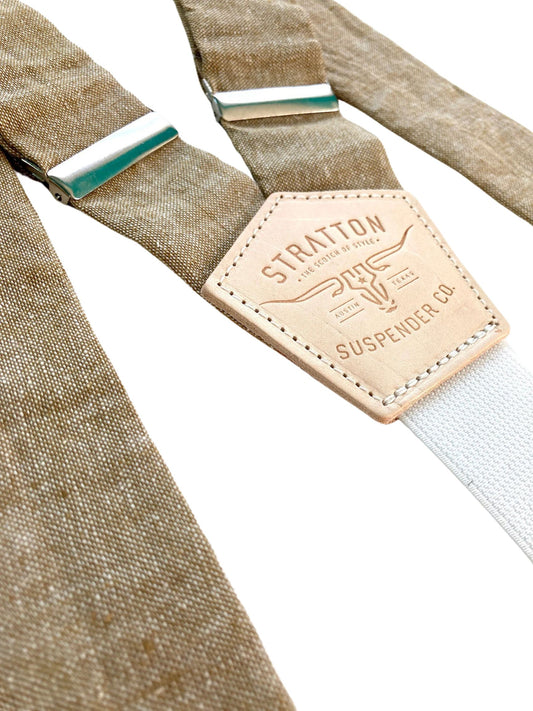 Detail shot of Stratton’s taupe linen suspenders with cream elastic back strap and branded leather patch, handmade in Texas for rustic groomsmen and formalwear styling.