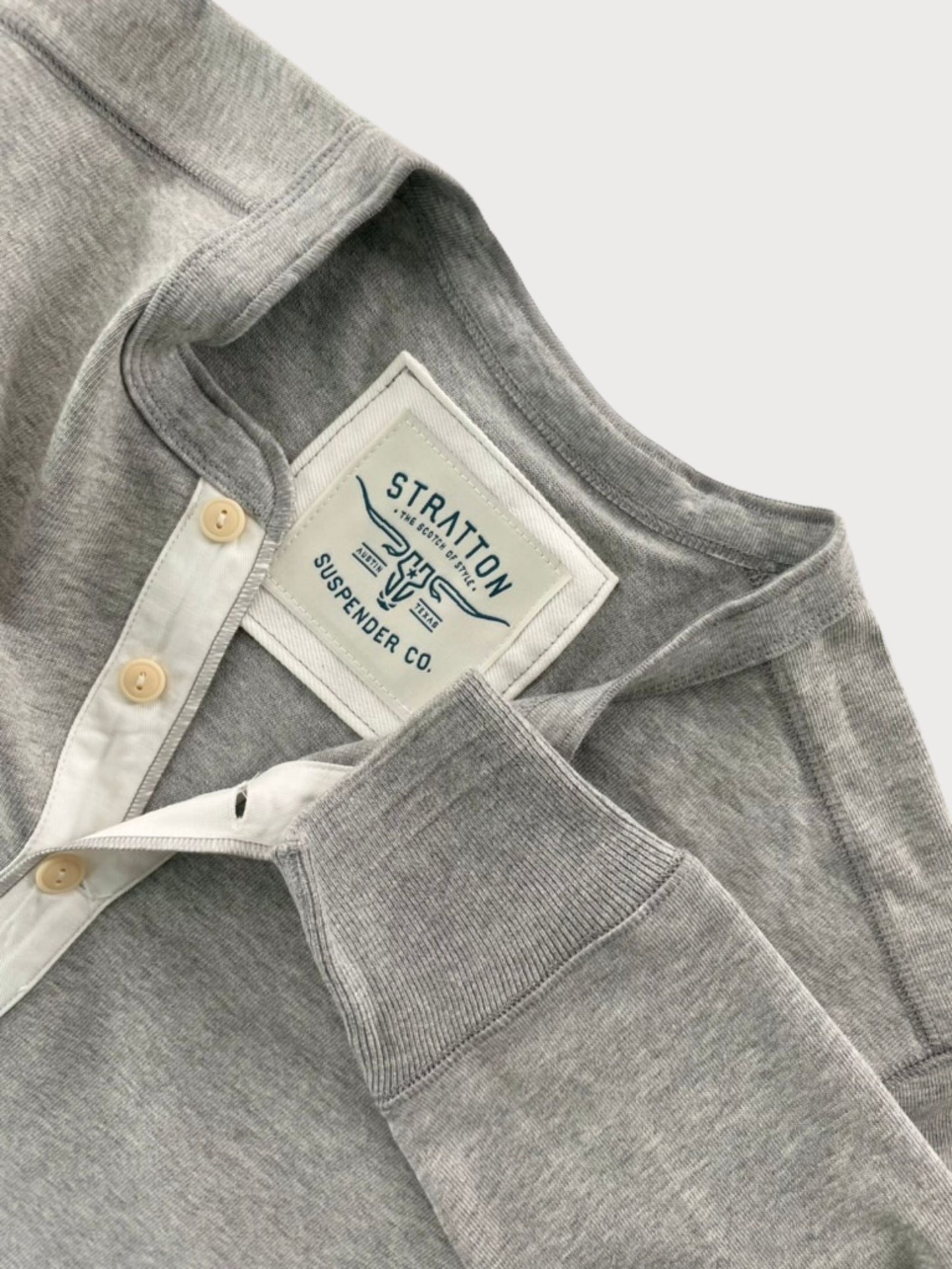 Close-up of Vintage 1940s Heather Gray Heavyweight Henley by Stratton Suspender Co., highlighting the ribbed sleeve cuff, three-button placket with contrasting white trim, and embroidered brand label. Made in the USA for durability and classic heritage workwear style.