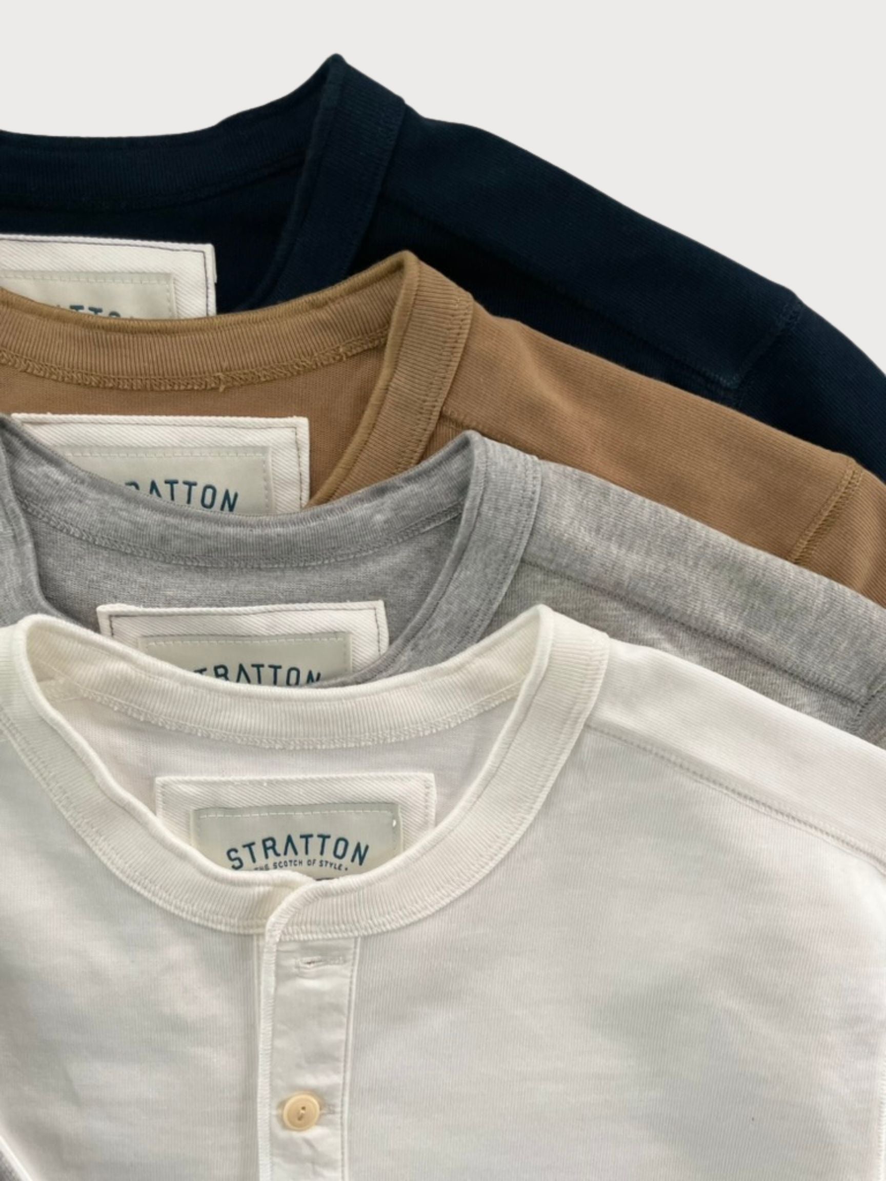 Stratton Suspender Co. Vintage 1940s Heavyweight Henley Shirts in Navy Blue, Tobacco Brown, Heather Gray, and Vintage White. Made in the USA from heavyweight cotton with a three-button placket and ribbed cuffs, designed for durability and classic workwear style.