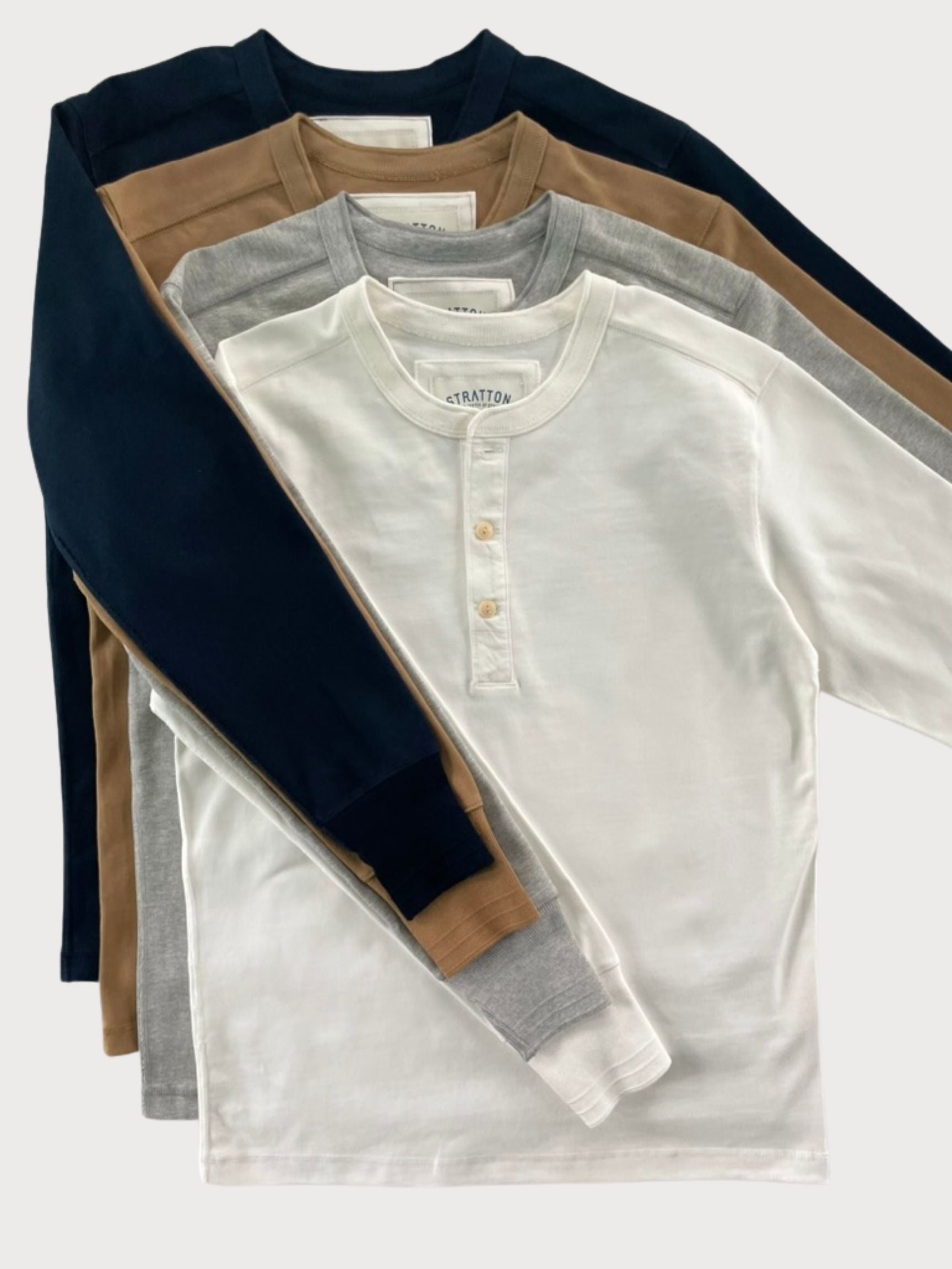 Stratton Suspender Co. Vintage 1940s Heavyweight Henley Shirts in Navy Blue, Tobacco Brown, Heather Gray, and Vintage White. Long-sleeve design with a three-button placket, ribbed cuffs, and heavyweight cotton for durable, classic workwear style. Made in the USA.