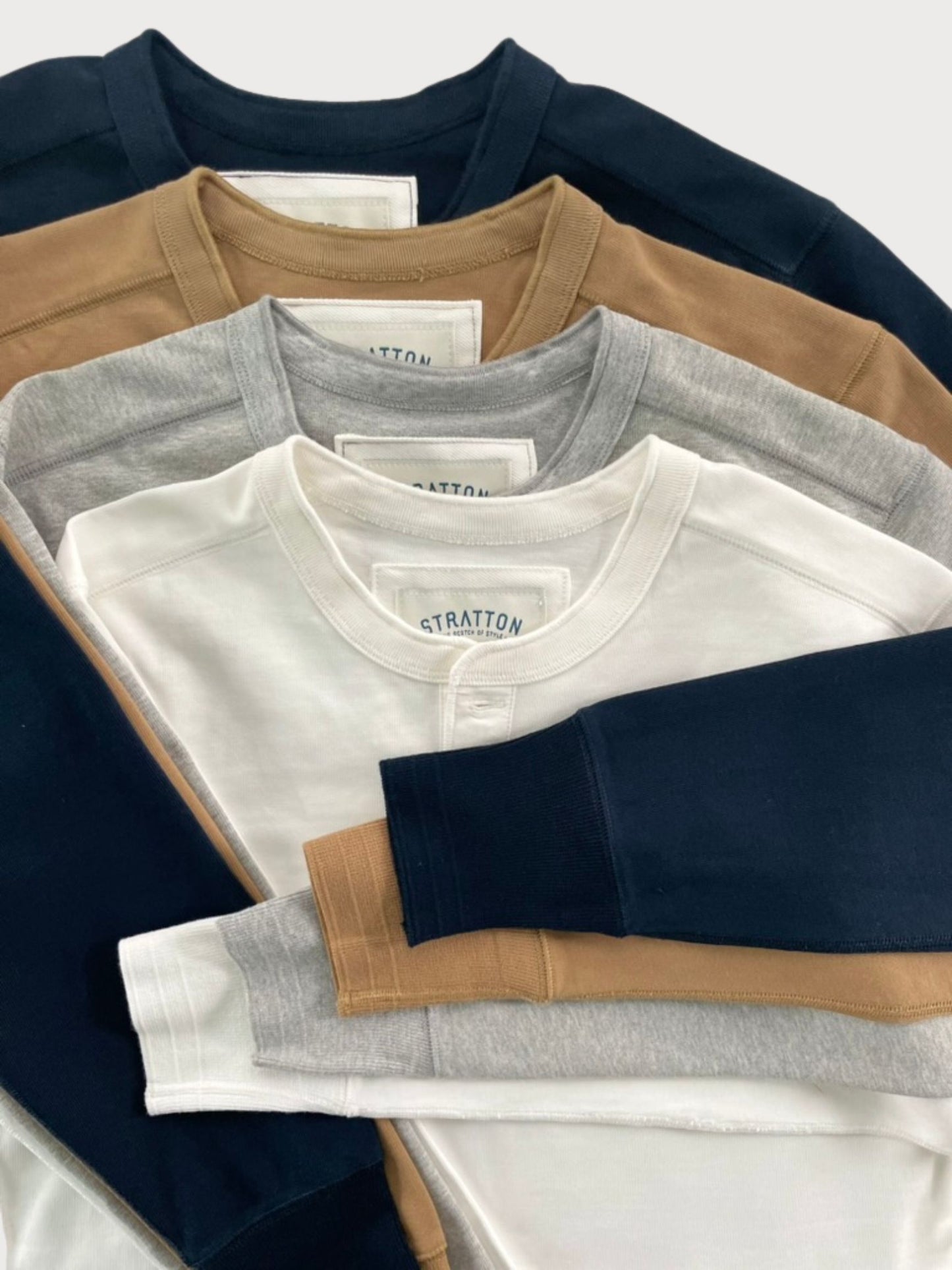 Stratton Suspender Co. Vintage 1940s Heavyweight Henley Shirt Collection in Navy Blue, Tobacco Brown, Heather Gray, and Vintage White. Made in the USA from heavyweight cotton, featuring ribbed cuffs and a three-button placket for a timeless heritage workwear style.