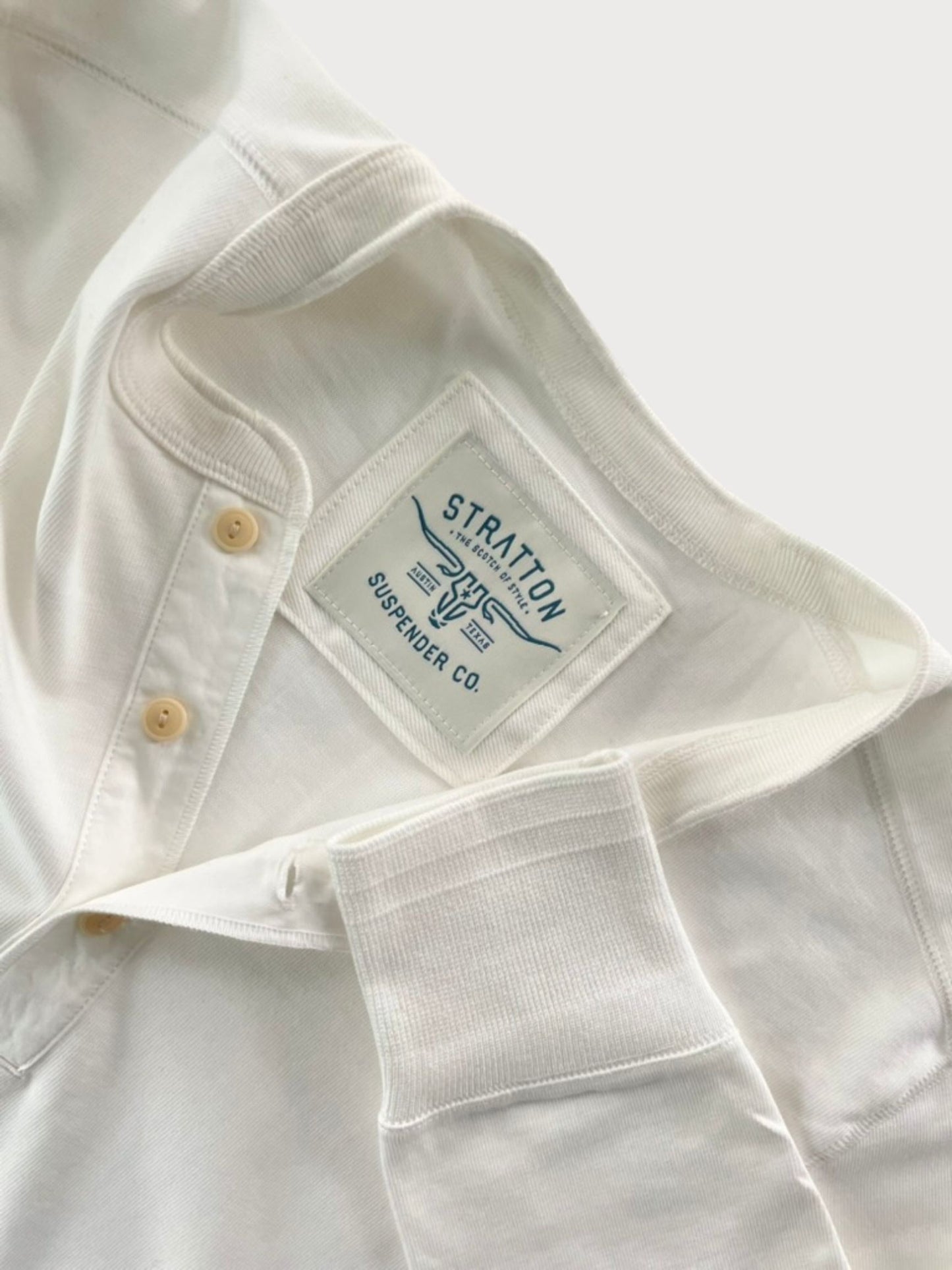 Close-up of Vintage 1940s White Heavyweight Henley by Stratton Suspender Co., highlighting the ribbed sleeve cuff, three-button placket, and embroidered brand label. Made in the USA from premium heavyweight cotton for durability and classic heritage workwear style.