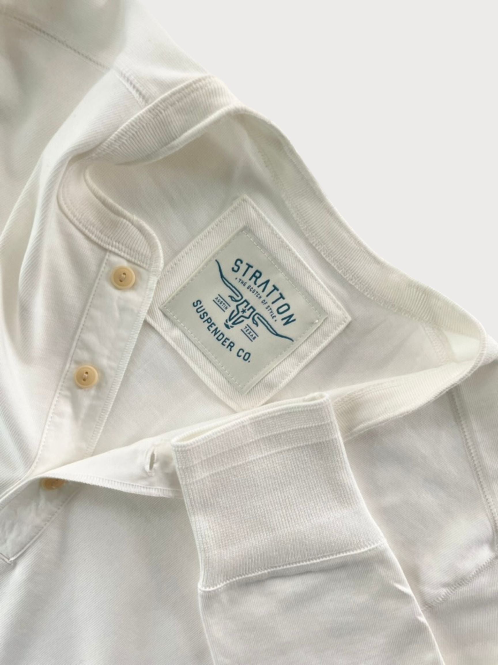 Close-up of Vintage 1940s White Heavyweight Henley by Stratton Suspender Co., highlighting the ribbed sleeve cuff, three-button placket, and embroidered brand label. Made in the USA from premium heavyweight cotton for durability and classic heritage workwear style.