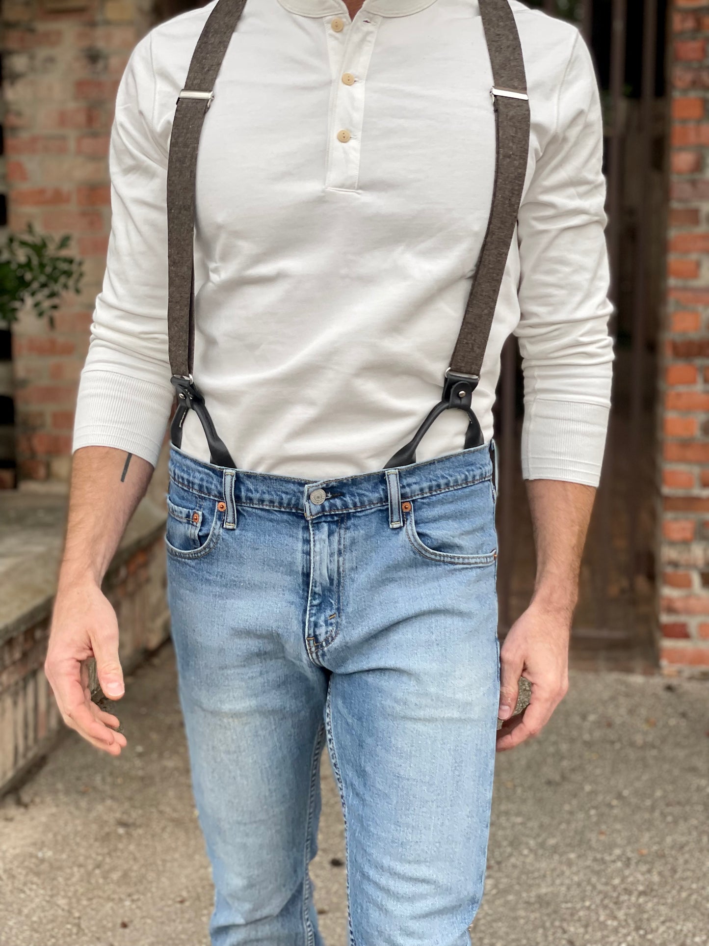 Close-up of a man wearing a Vintage White Henley and brown wool suspenders by Stratton Suspender Co., styled with classic denim. A heritage workwear look combining rugged craftsmanship with timeless American menswear.