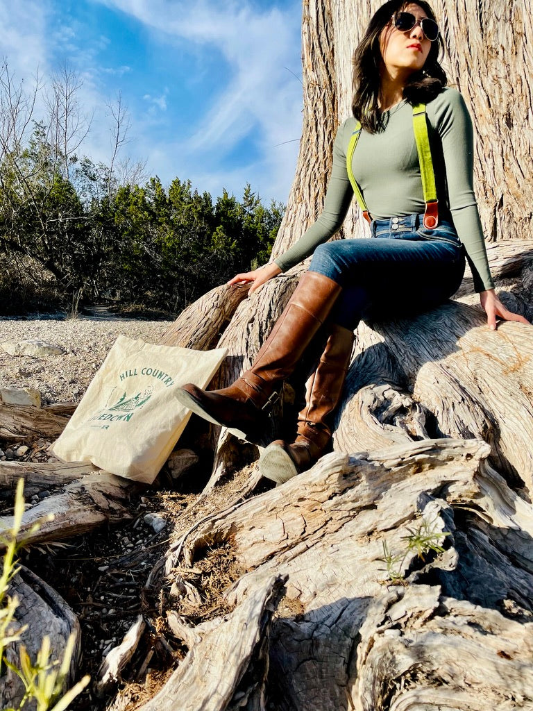 Chartreuse green linen women’s suspenders styled with boots and denim in a boho fall outfit—shot in the Texas Hill Country.