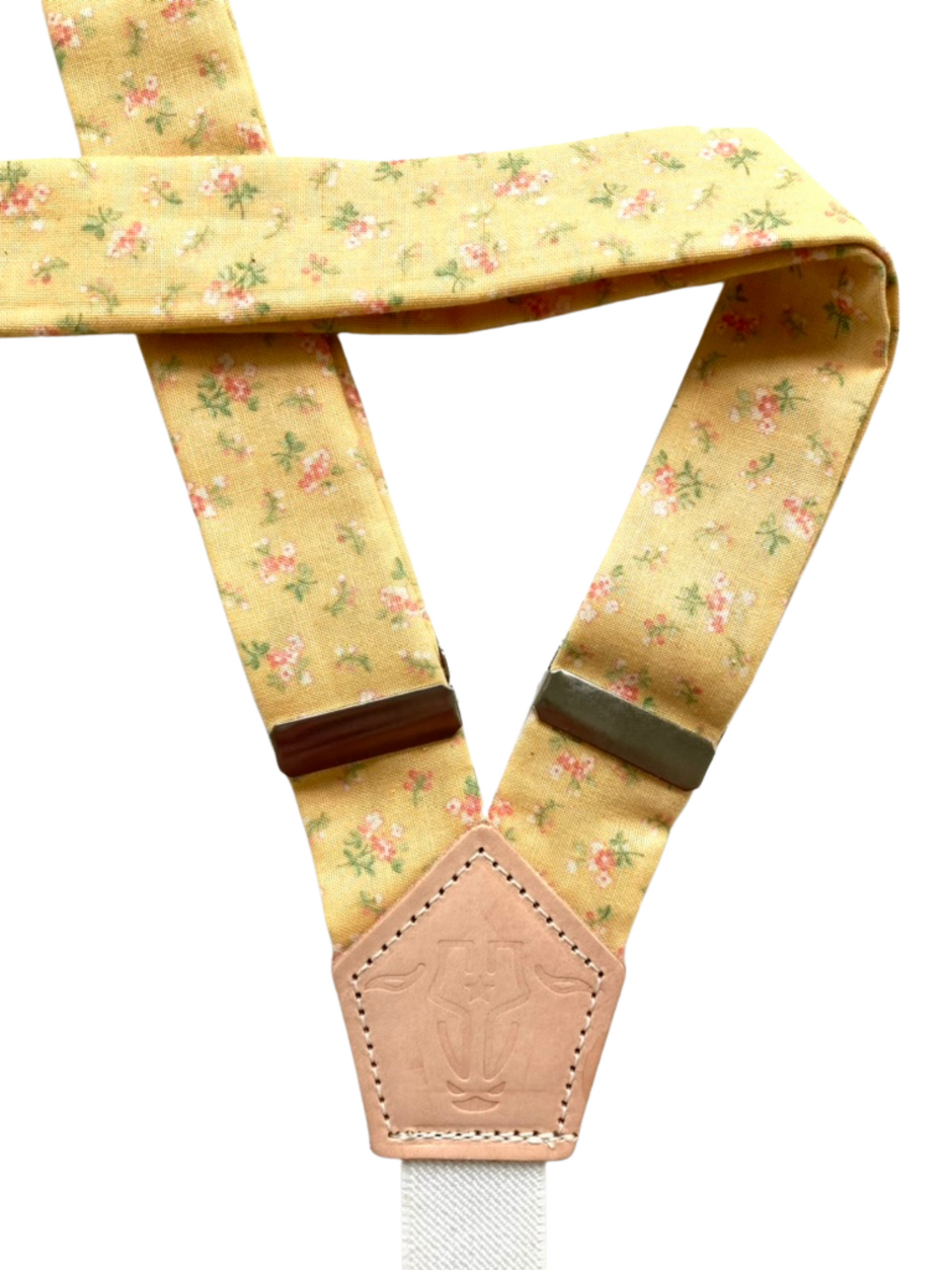 Close-up of yellow floral women’s suspenders with soft cotton straps and polished hardware.