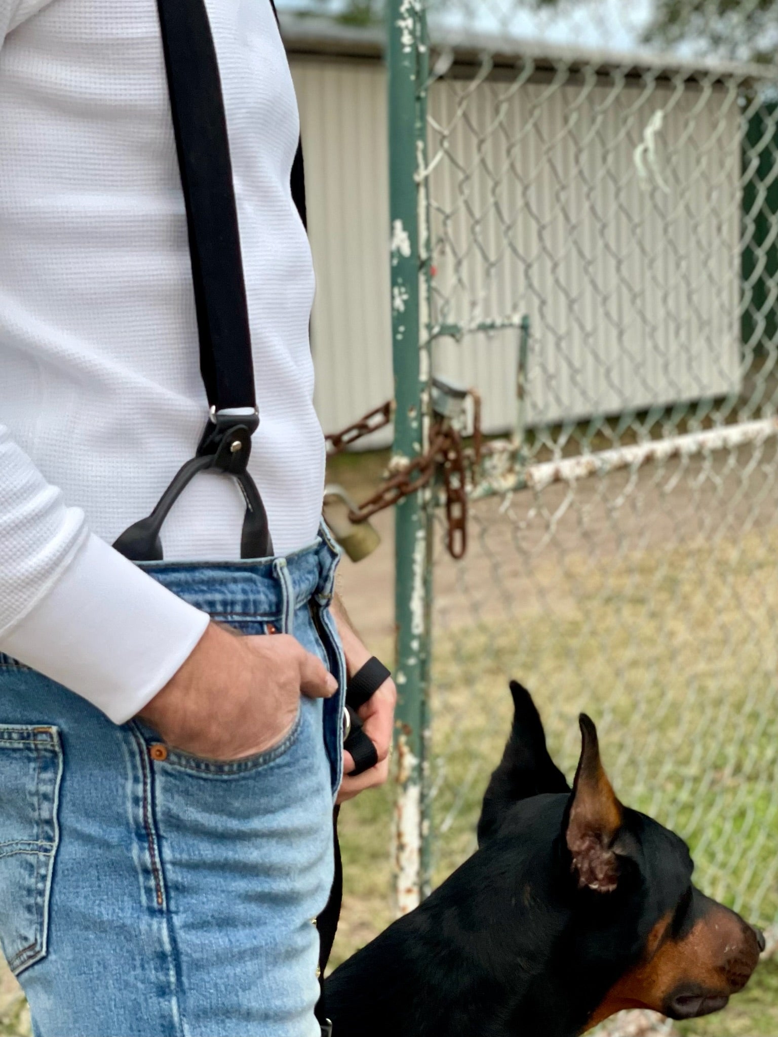 Handmade black linen button-on suspenders with full-grain veg-tan leather and premium woven elastic. Ethically crafted in Texas for timeless heritage menswear, rugged denim, and classic American style. European Doberman adds a bold, refined touch to the scene.