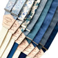A collection of blue floral and linen suspenders with ivory, navy, and deep blue back straps. Handmade button-on suspenders with premium leather back patches, designed for weddings, groomsmen, and vintage menswear enthusiasts. Timeless, heritage-inspired style with classic craftsmanship.