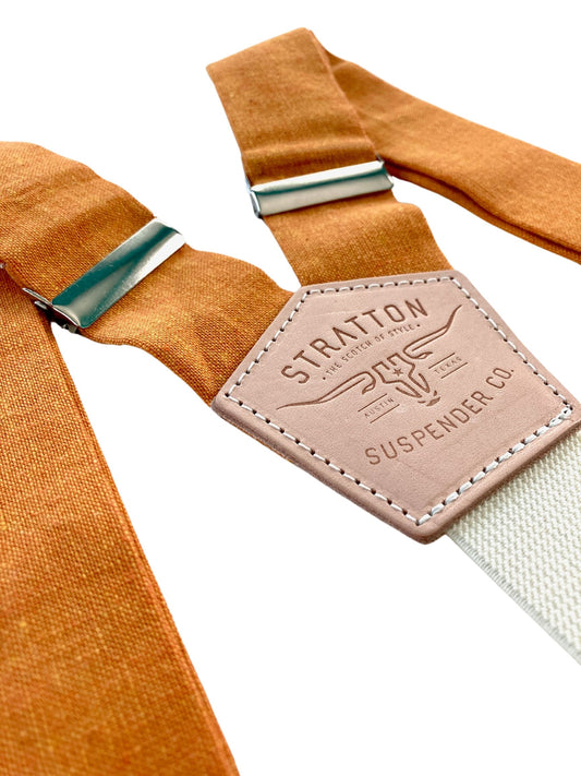 Stratton Suspender Co. features the orange linen suspenders on veg tan shoulder leather with cream colored elastic back strap for the Fall 2022 suspenders collection