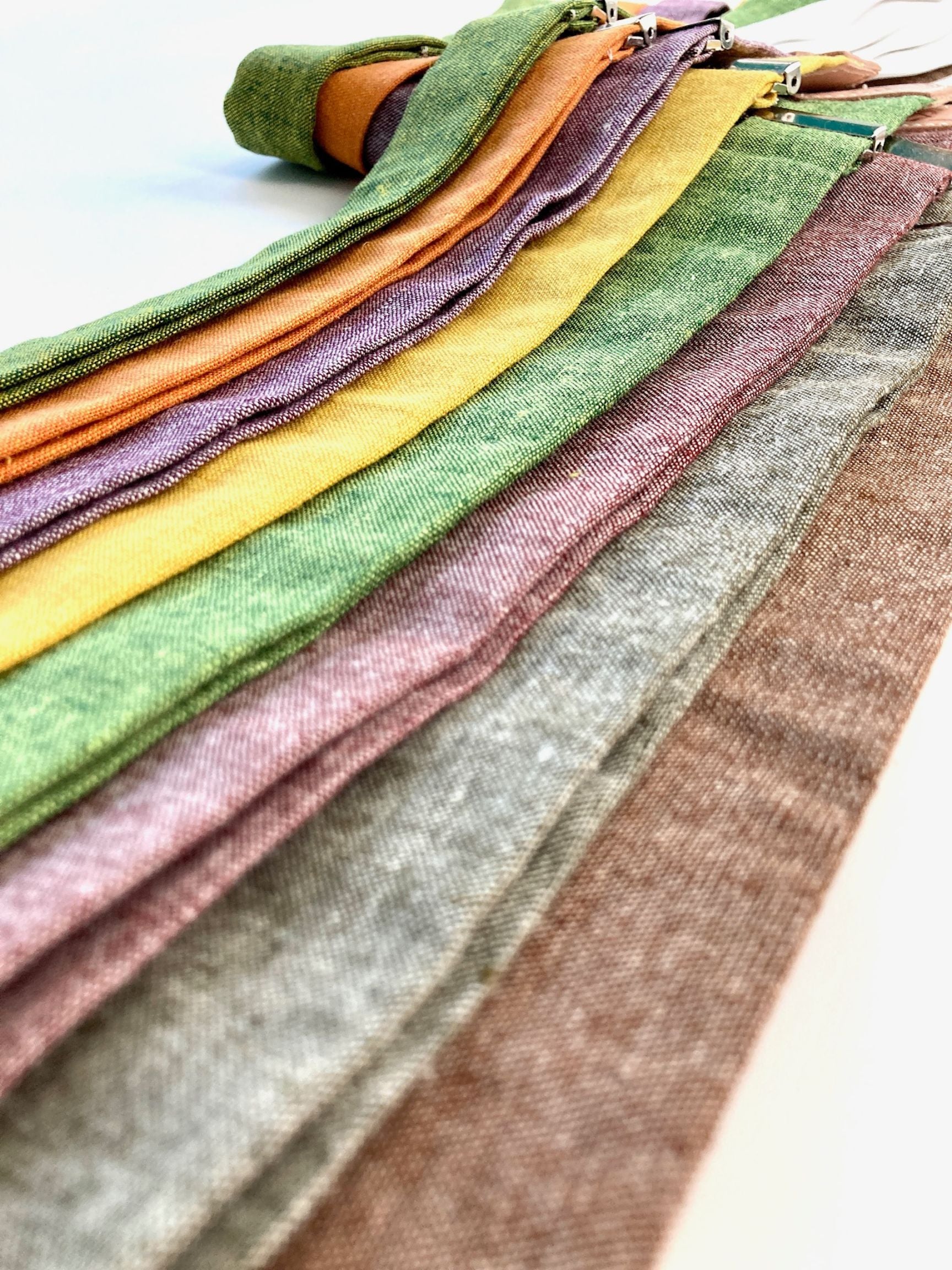 Close up photo of Stratton Suspender Co. Linen Formal Suspender Straps in Nutmeg, Olive, Rust, Kelly Green, Mustard Yellow, Plum Purple, Tangerine Orange, and palm or Chartreuse Green
