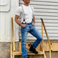 Man wearing handmade Charcoal Linen Suspenders with black leather button-on attachments, fitted vintage white tee, and classic denim jeans. Styled with black boots for a rugged yet refined heritage menswear look. Ethically handmade in Texas by Stratton Suspender Co.