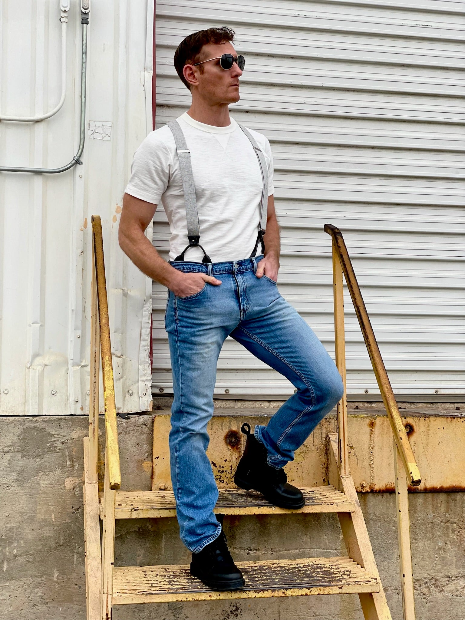Man wearing handmade Charcoal Linen Suspenders with black leather button-on attachments, fitted vintage white tee, and classic denim jeans. Styled with black boots for a rugged yet refined heritage menswear look. Ethically handmade in Texas by Stratton Suspender Co.
