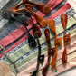 A collection of handmade vintage wedding suspenders in sapphire blue floral, gray paisley, black, navy, cherry red, pistachio green, beige, and pastel pink. Features full-grain veg-tan leather button-on and magnetic clasp attachments in cognac, tan, chocolate, and black. Designed for grooms, groomsmen, and classic menswear enthusiasts, these suspenders offer heritage craftsmanship with modern versatility—perfect for formal events, rustic weddings, and timeless styling.