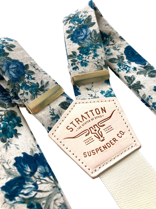 Close-up of Heritage Blue Floral Linen Suspenders with a premium veg-tan leather back patch and handcrafted button-on leather attachments in black, chocolate, cognac, and tan. Designed for weddings, groomsmen, and vintage menswear. Ethically handmade by Stratton Suspender Co.