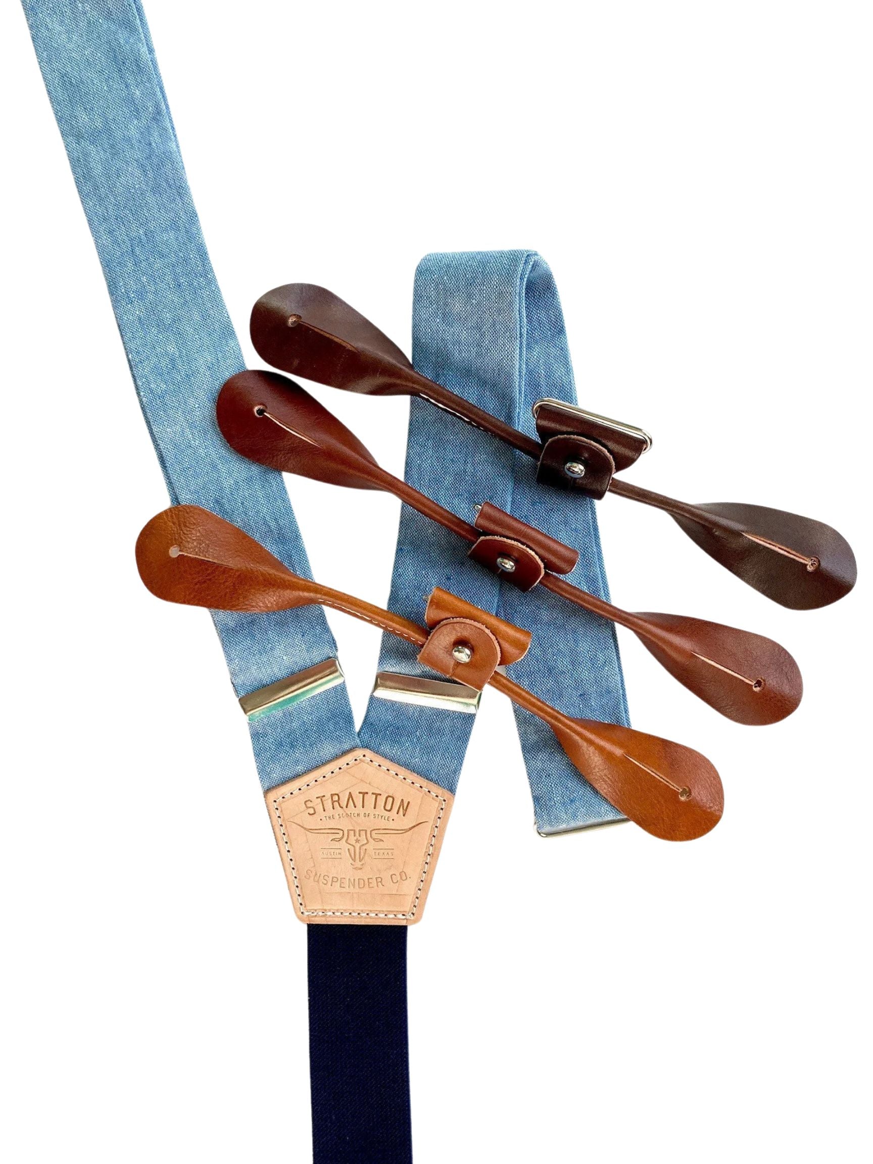 Handmade light blue linen suspenders with navy elastic back strap and full-grain veg-tan leather button attachments in whiskey cognac, chocolate, and dark honey tan. Ethically made by Stratton Suspender Co. in Texas. Ideal for weddings, groomsmen, and heritage menswear.