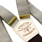 Close-up of Stratton’s Mushroom linen wedding suspenders featuring soft beige-taupe straps, golden brass adjusters, and the brand’s signature leather patch over a dark brown elastic back strap.