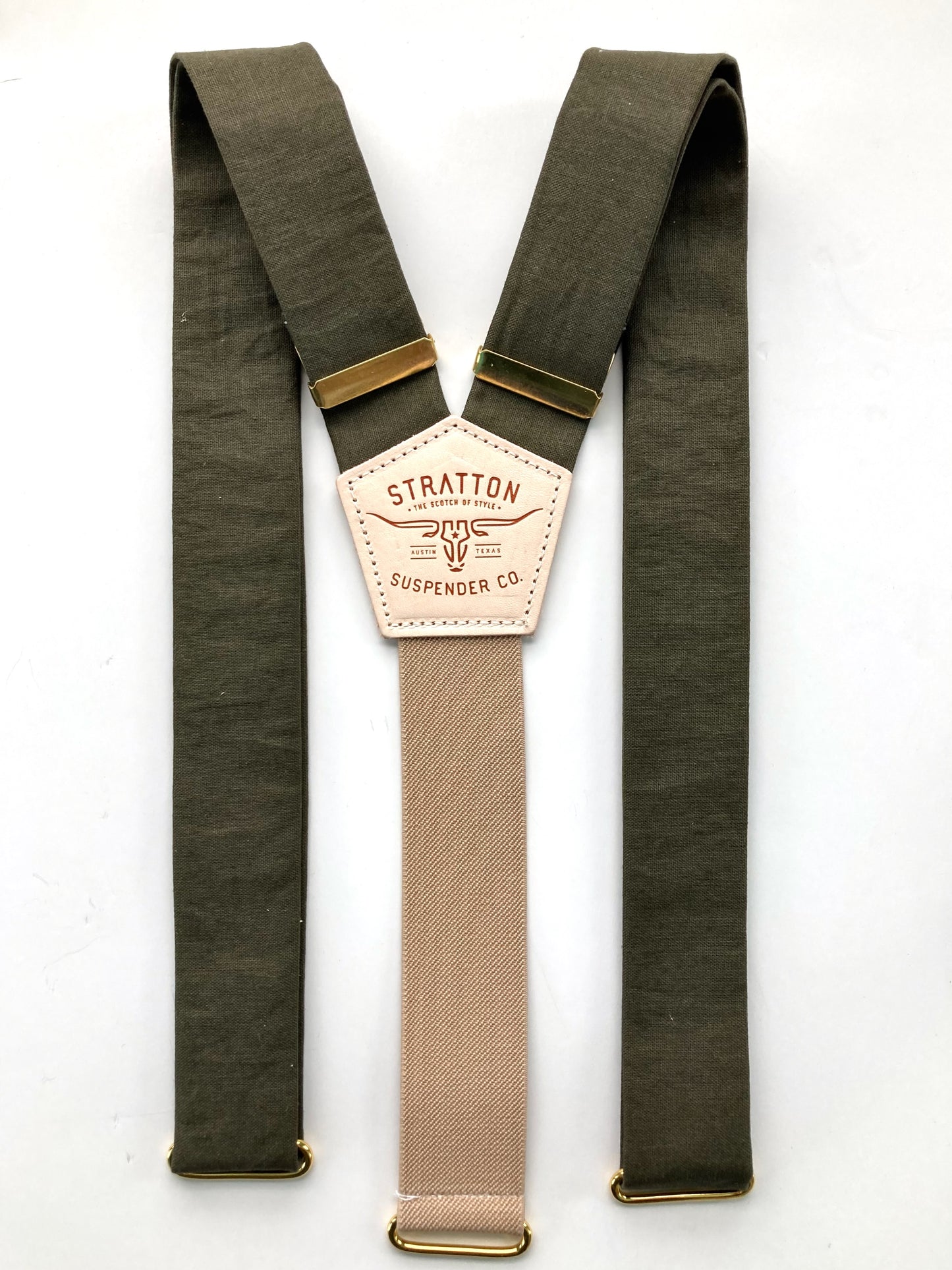 Flat-lay of olive green linen suspenders with a taupe back strap, brass hardware, and premium craftsmanship. Features a hand-stitched leather back patch and vintage-inspired design. Ideal for weddings, groomsmen, and heirloom menswear.