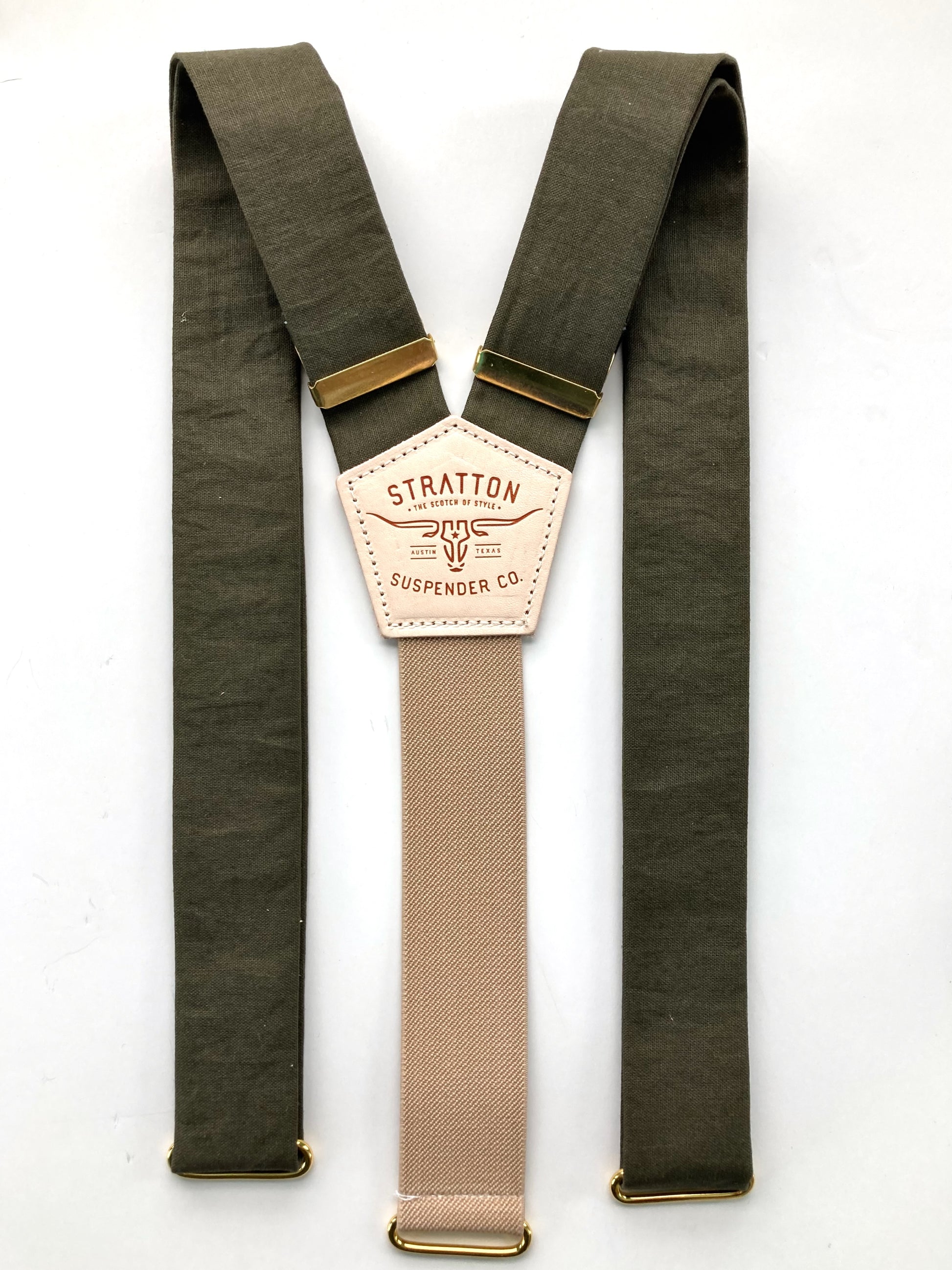 Flat-lay of olive green linen suspenders with a taupe back strap, brass hardware, and premium craftsmanship. Features a hand-stitched leather back patch and vintage-inspired design. Ideal for weddings, groomsmen, and heirloom menswear.