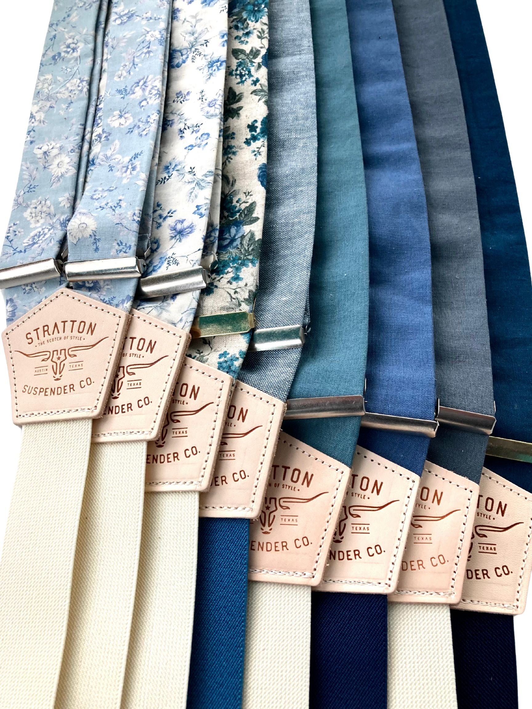 A collection of handcrafted linen button-on suspenders in powder blue floral, Victorian cornflower blue floral, rustic blue floral, sky blue with ocean blue, teal, French blue with navy, slate blue, and navy with midnight blue. Designed for weddings, groomsmen, and vintage menswear enthusiasts. Featuring a premium leather back patch and an adjustable fit.