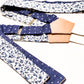 Handmade wedding suspenders in sapphire blue floral and vintage blue polka dot patterns, crafted with premium veg-tan leather back patch and white woven elastic straps. Designed for grooms, groomsmen, and vintage menswear enthusiasts, these button-on suspenders offer timeless style for formal events, rustic weddings, and classic gentleman's attire. Perfect for pairing with navy suits, linen wedding looks, or tailored menswear.