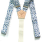 Flat-lay image of Sapphire Blue Floral wedding suspenders, featuring a delicate vintage-inspired blue floral pattern on premium linen straps. Designed with a full-grain vegetable-tanned leather back patch, polished silver-tone hardware, and a soft woven elastic back strap for comfort and flexibility. These button-on suspenders are perfect for grooms, groomsmen, and vintage wedding themes, offering a refined, tailored look superior to clip-ons. Handmade for formalwear, rustic weddings, and timeless menswear 