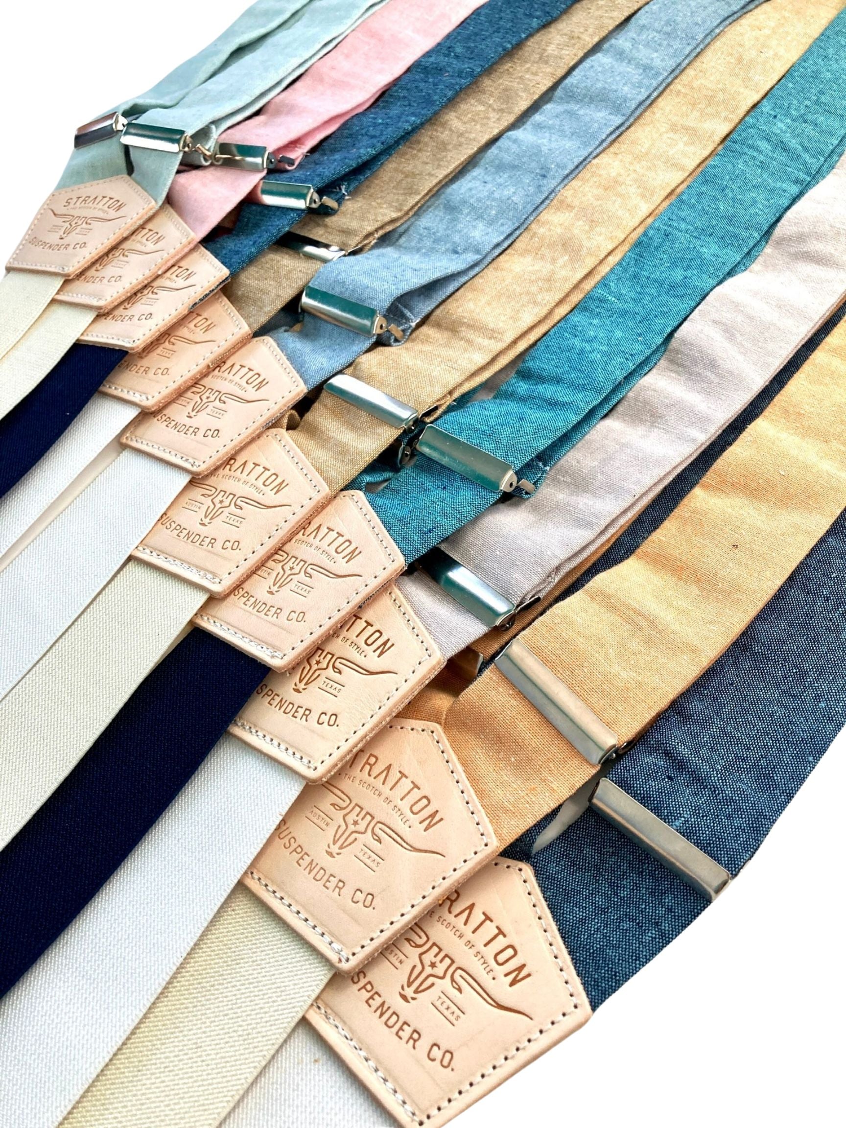 A collection of pastel and neutral linen suspenders, featuring handcrafted leather back patches and silver hardware. Ideal for spring and summer weddings, groomsmen, and timeless menswear. Ethically made by Stratton Suspender Co.