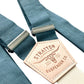 Close-up of handcrafted teal blue linen suspenders with a cream back strap and premium leather detailing. Ideal for wedding suspenders, groomsmen attire, and formal menswear.
