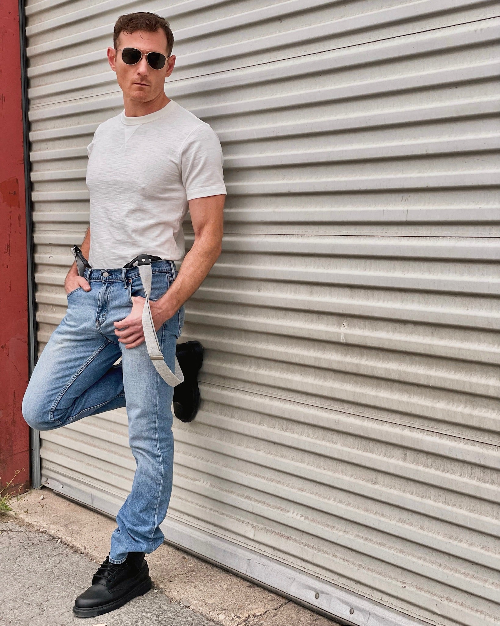 Man wearing black linen suspenders with a vintage white tee and light-wash jeans, styled for modern Western menswear. Effortless Austin Texas street style with rugged heritage American craftsmanship. Perfect for casual menswear and laid-back charm.
