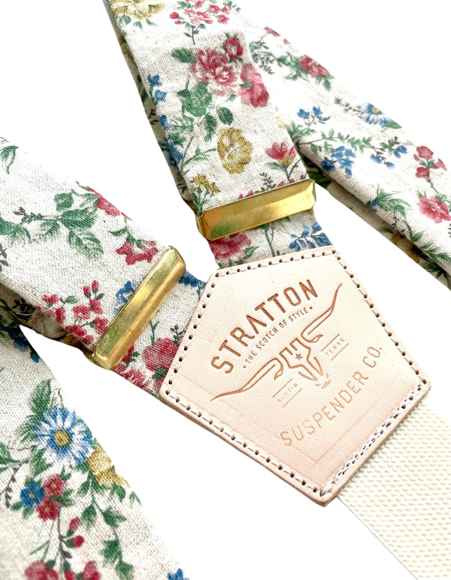 Close-up of beige floral linen wedding suspenders featuring heavyweight linen fabric, vintage floral design, and polished gold hardware. Handcrafted in Texas for groomsmen gifts, rustic weddings, and heritage menswear.