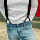 Black linen button-on suspenders styled casually with a white waffle knit shirt and blue jeans, showing black leather tabs and silver adjusters—handmade in Texas for groomsmen and vintage menswear.